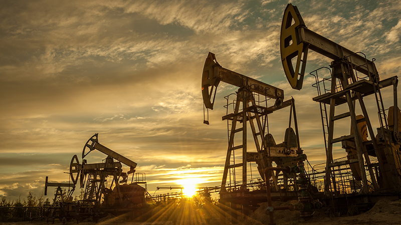 oil and gas pump jack against golden sunset